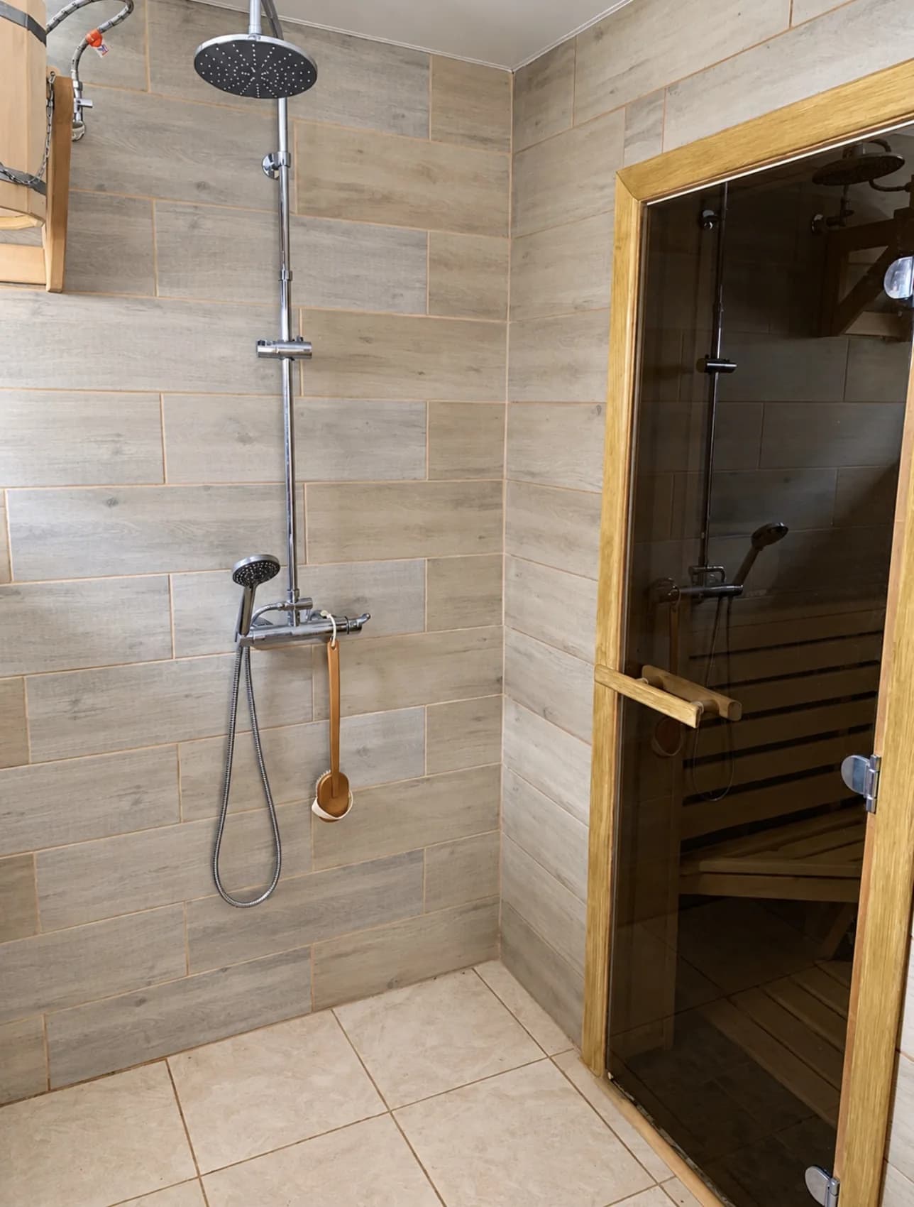 A wood-lined sauna and adjacent tiled shower area.