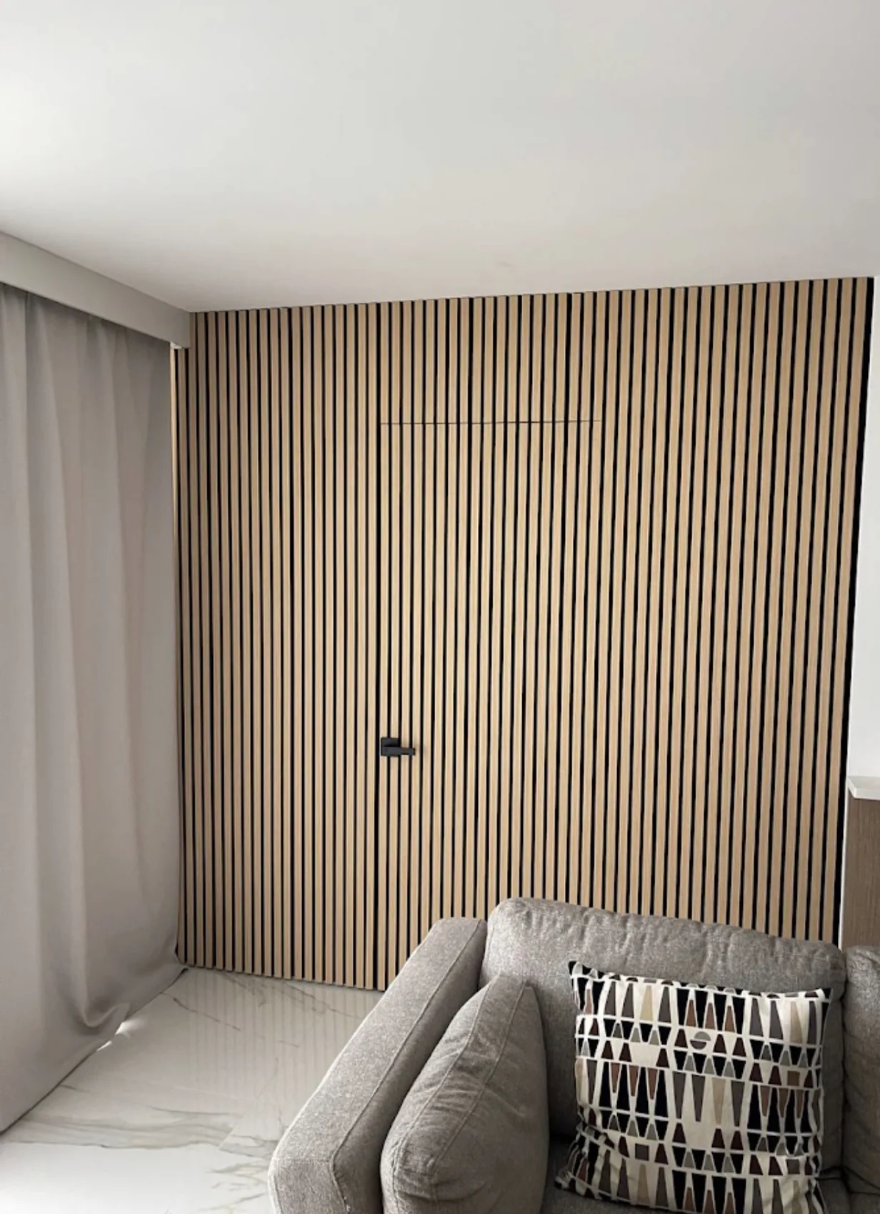 Vertical wood slats form a full-height accent within a living space.