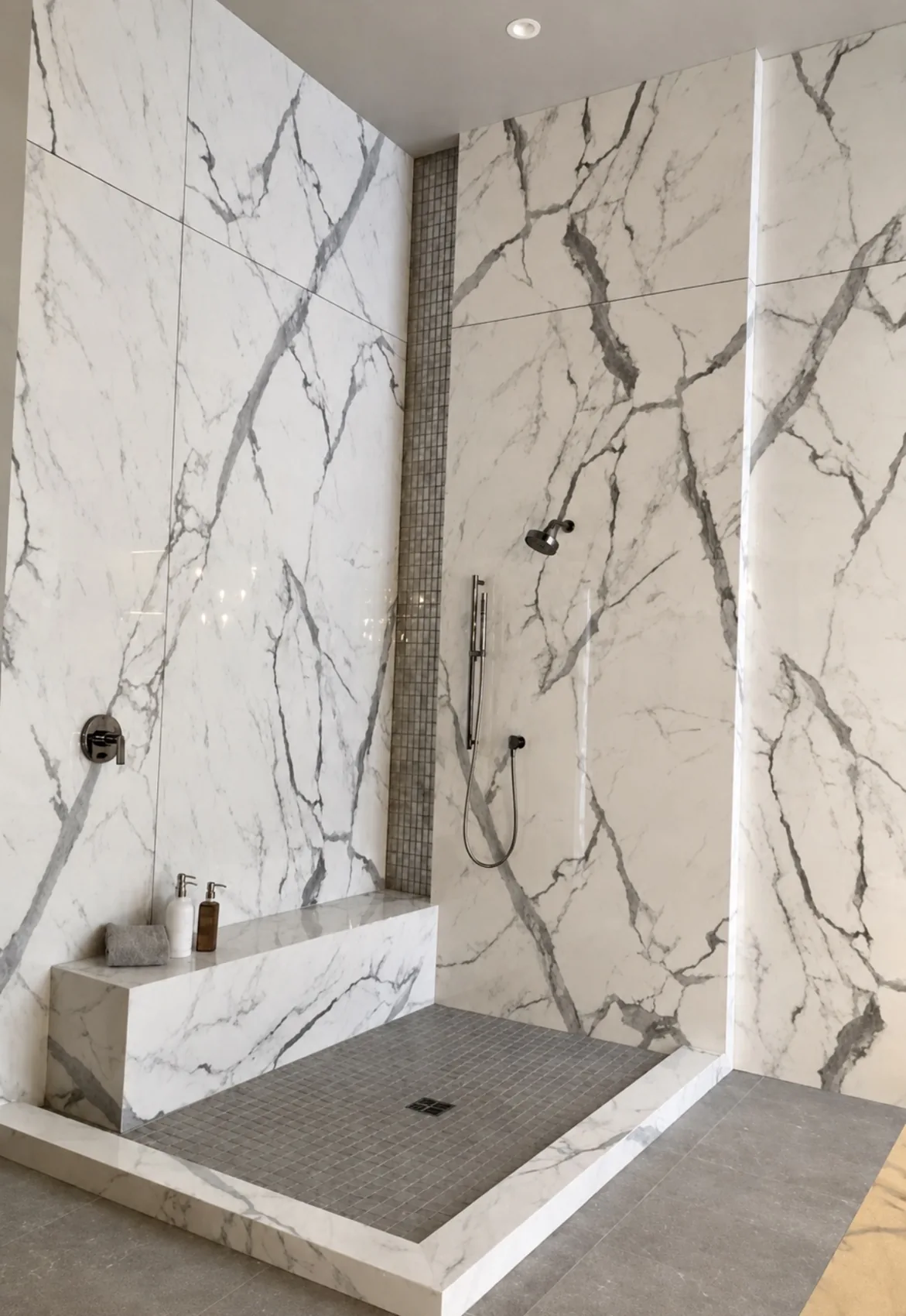 Large-format veined shower wall tile with floating bench