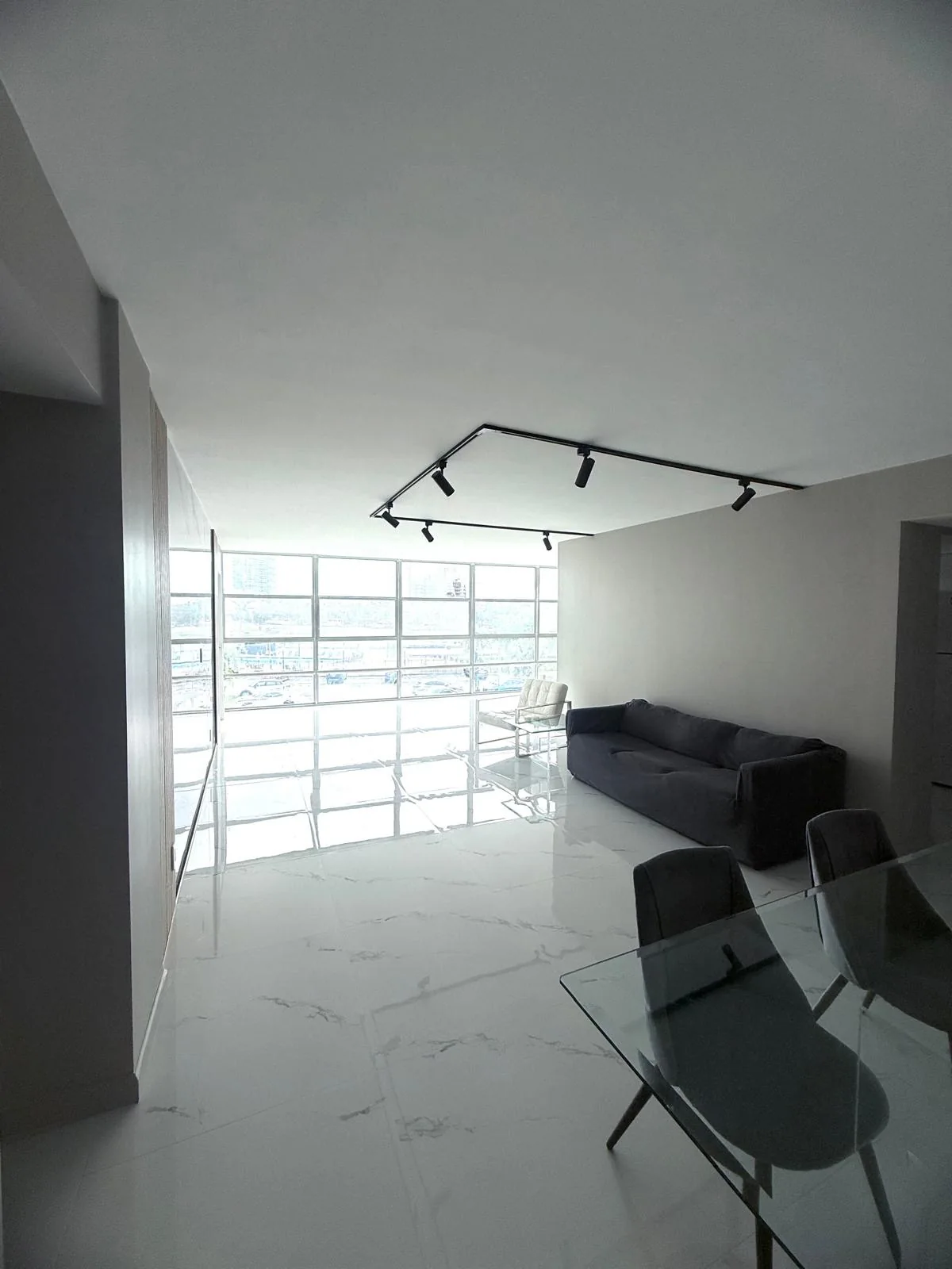 A coordinated interior with marble-look surfaces, vertical wood accents and track lighting.