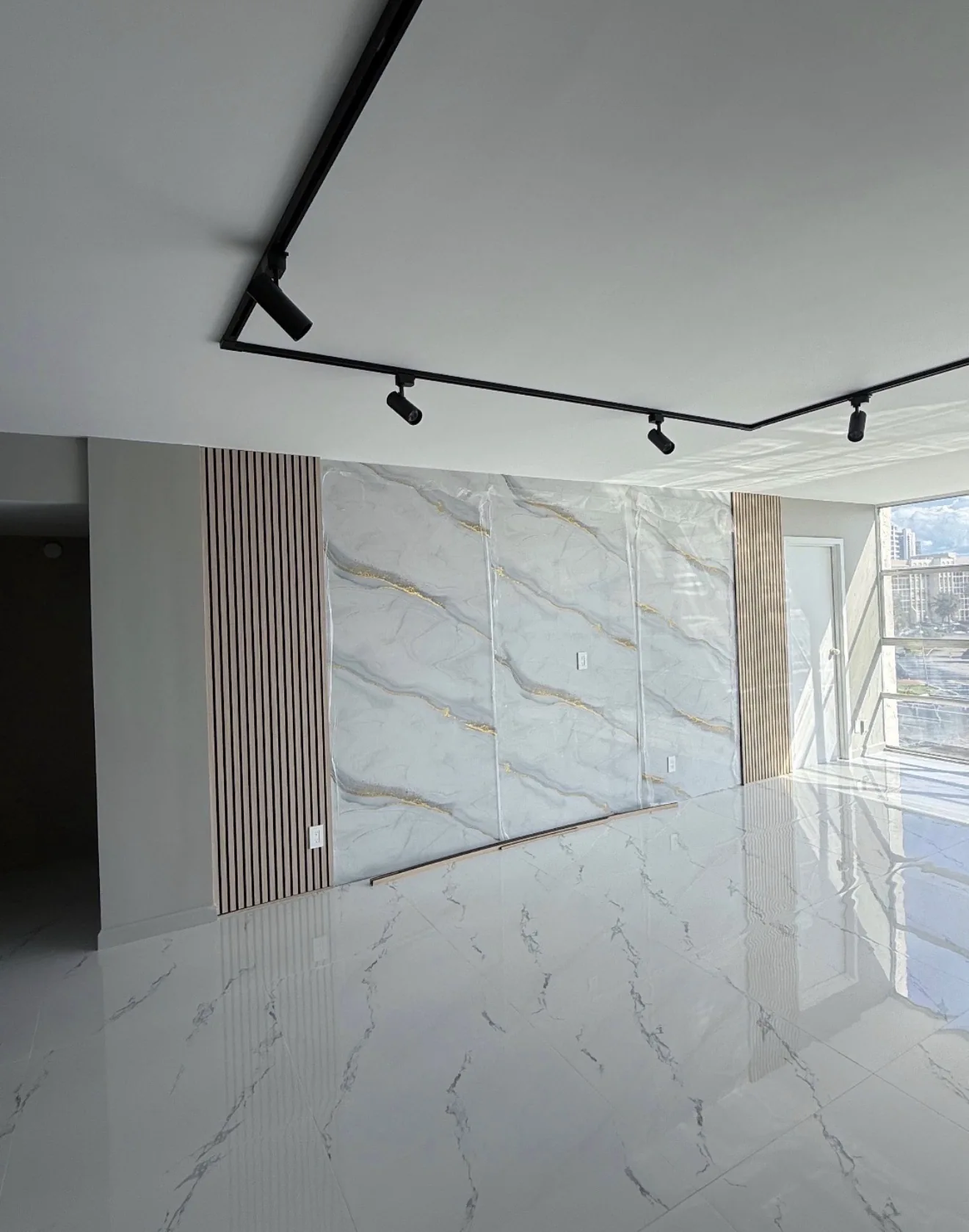 Living room with marble-look feature wall and wood accents