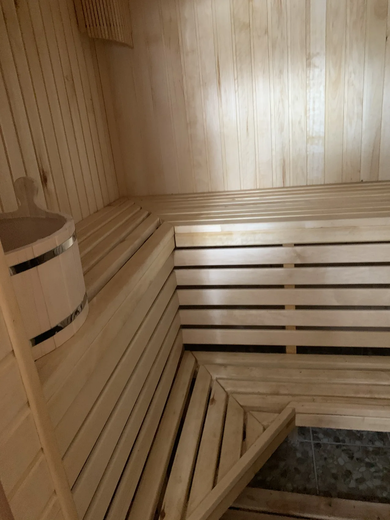 A wood-lined sauna and adjacent tiled shower area.
